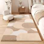 Pebble faux cashmere bedroom rug, scattered pebble shapes in sand tones, beside a bed