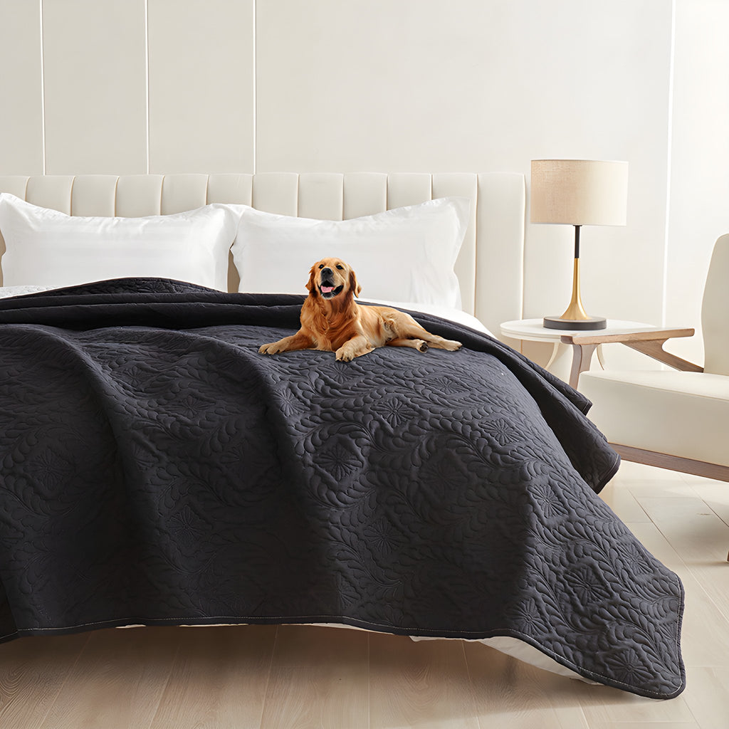Black quilted waterproof bed cover on a bed with a golden retriever lying on top