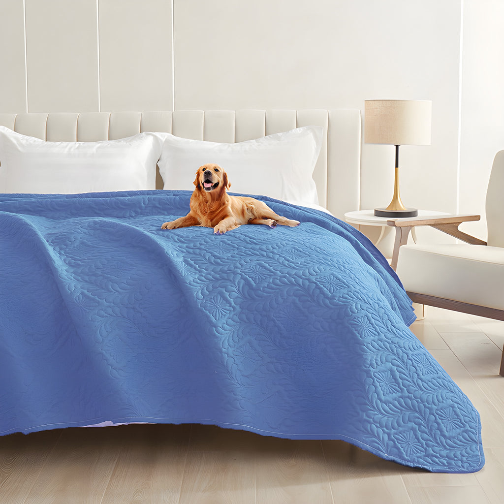 Blue quilted waterproof bed cover on a bed with a golden retriever lying on top