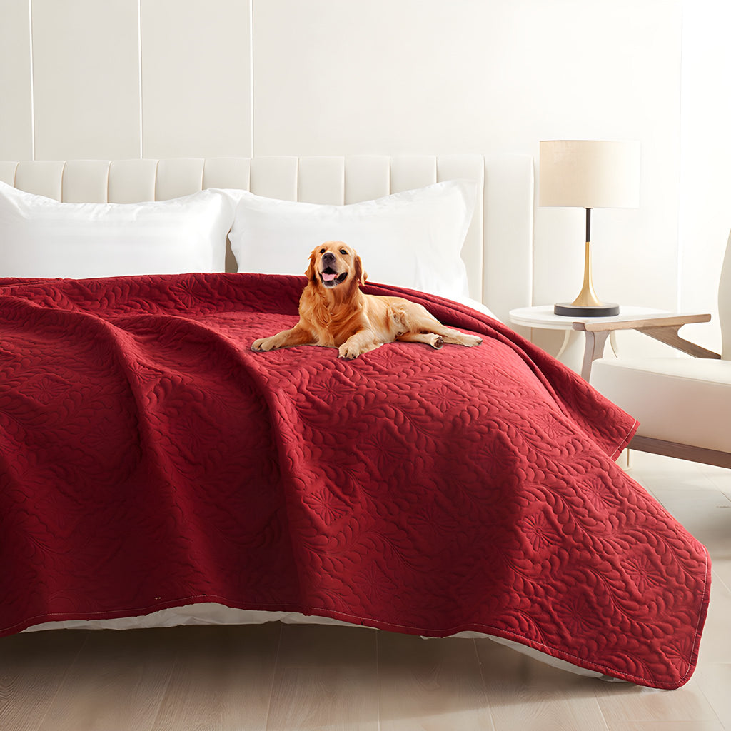 Red quilted waterproof bed cover on a bed with a golden retriever lying on top