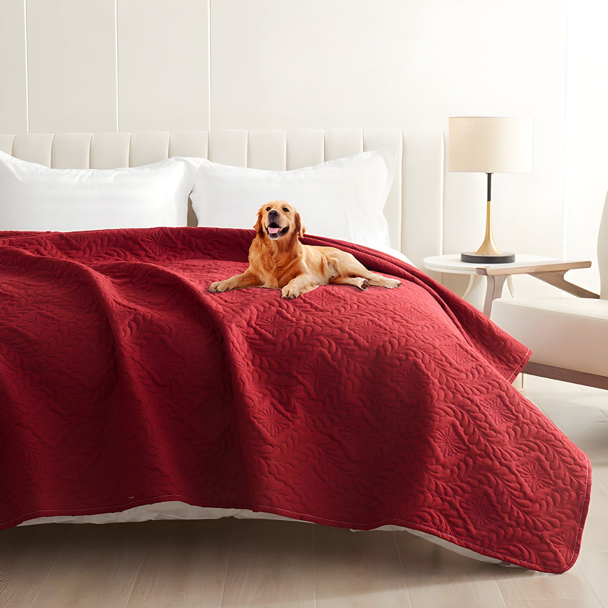 Red quilted waterproof bed cover on a bed with a golden retriever lying on top