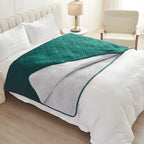 Emerald green quilted waterproof bed cover draped over a white made bed with the light reverse turned back